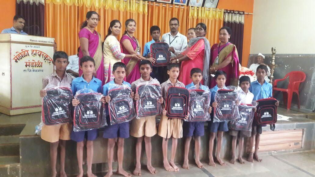 Children holding new school bags distributed by Naari Shakti